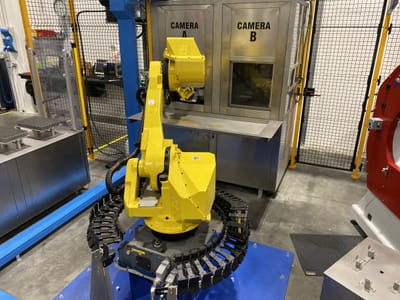 Robot che presenta il pezzo alle telecamere di controllo