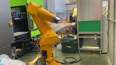 Robot al servizio di una pressa a iniezione